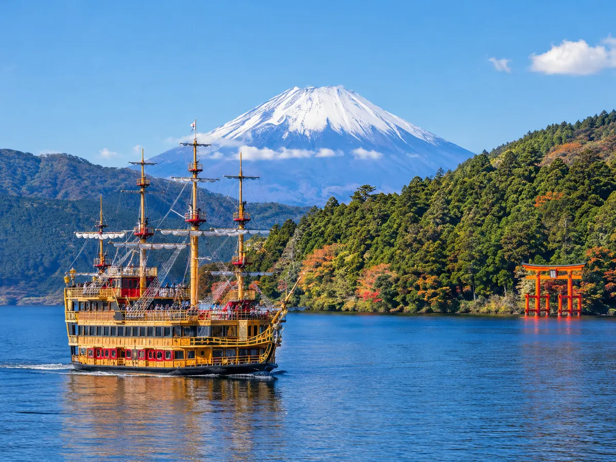 Ein Ausflugsschiff auf dem Lake Ashi auf ruhigem Wasser mit dem Mt Fuji in der Ferne